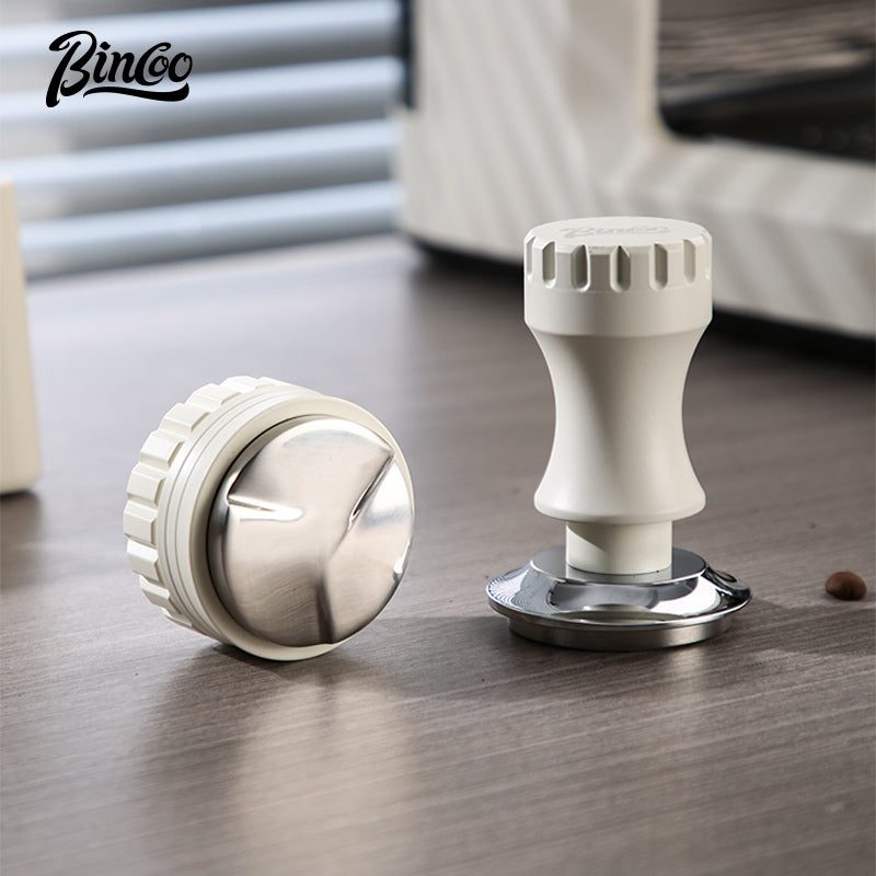 Distributor Bincoo màu kem và tamper đặt trên mặt quầy gỗ